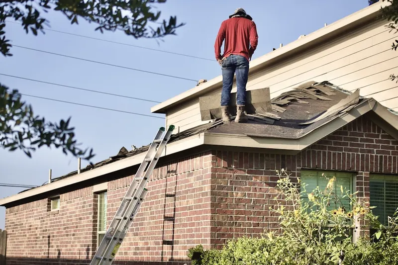 Professional roofer working on a residential roof in Algoma